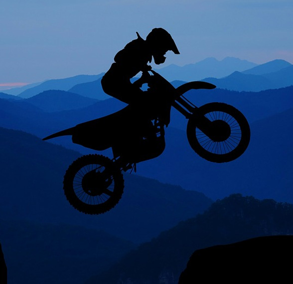 Silhouette of a motorcyclist jumping